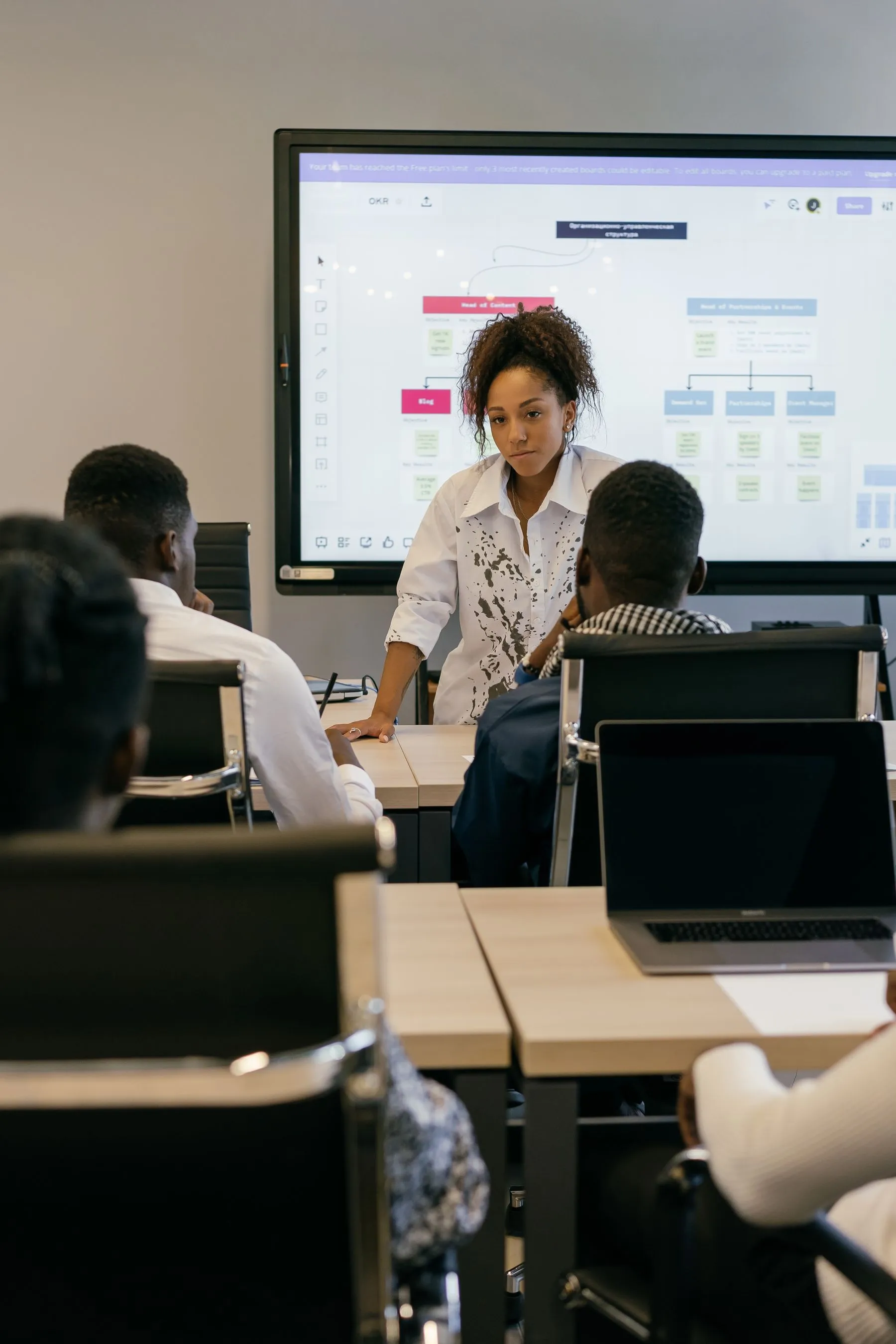 A consultant presenting a diagram to a small team.